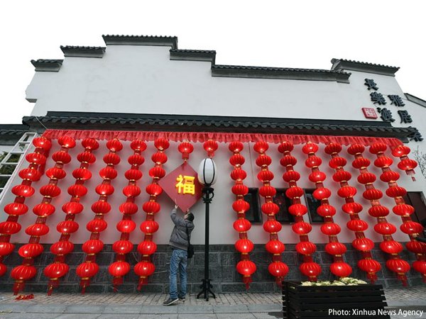 Photo: A worker putting the finishing touches to New Year decorations in Nanjing.(Xinhua News Agency)