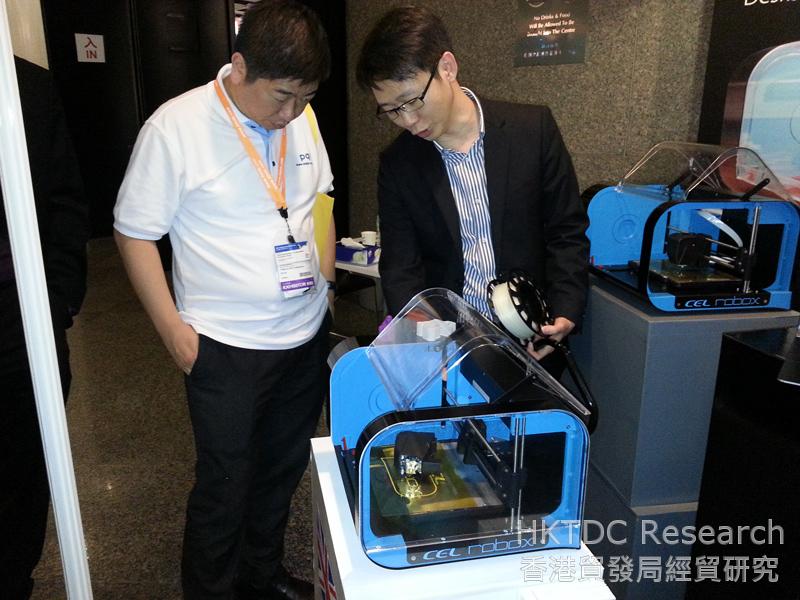 Photo: An exhibitor demonstrates a 3D printer at the fair