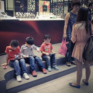 相片:孩子在街上玩平板电脑的游戏 相片:孩子在街上玩平板电脑的游戏