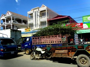Photo: Trucks driving down a street in Phnom Penh. 